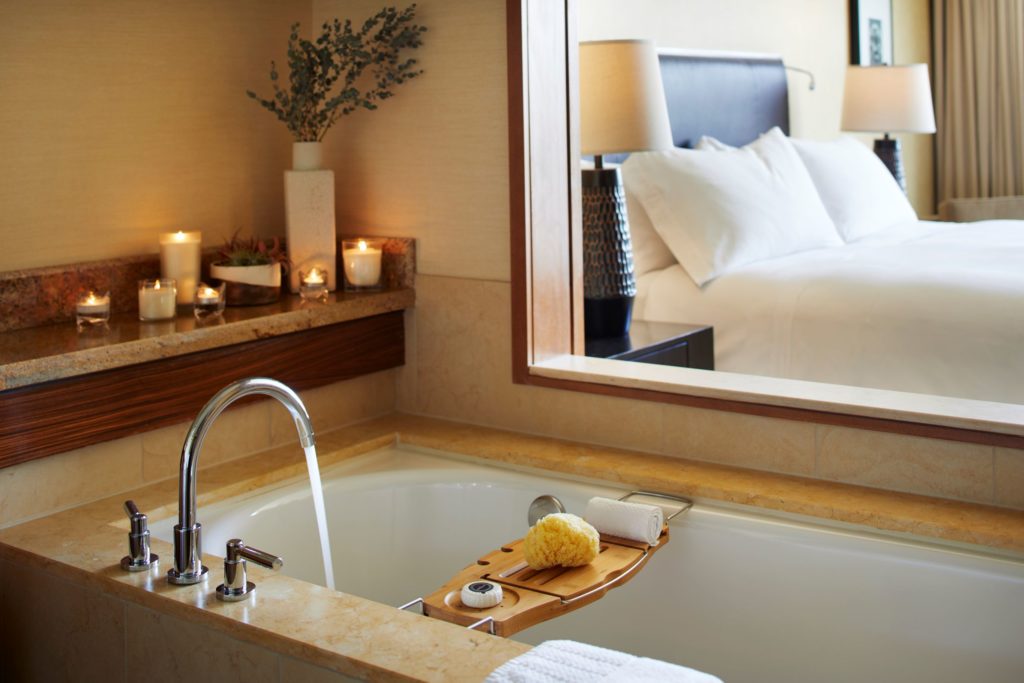 Bathtub with view of bed in guest room at Pan Pacific Seattle