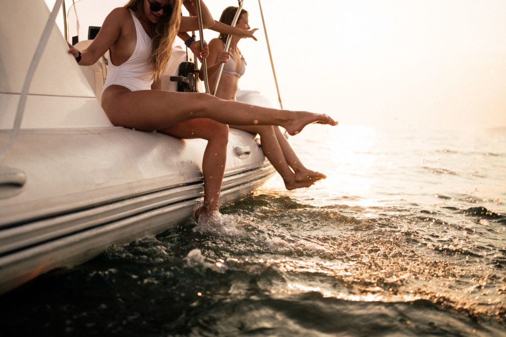 Friends having fun on sailboat and enjoying summer days