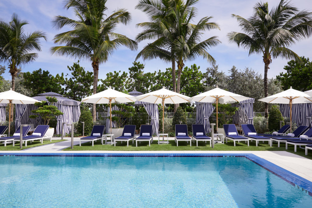 Outdoor pool, lounge chairs, and cabanas at Cadillac Hotel & Beach Club in Miami Beach, FL