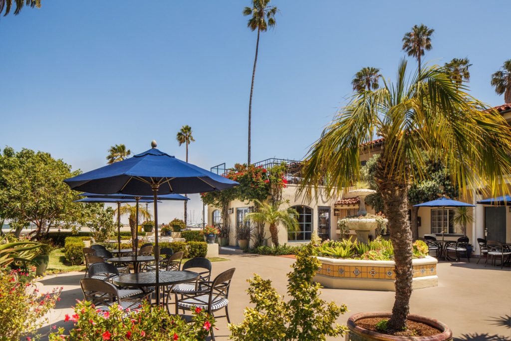 Outdoor courtyard with tables and umbrellas at Hotel Milo Santa Barbara