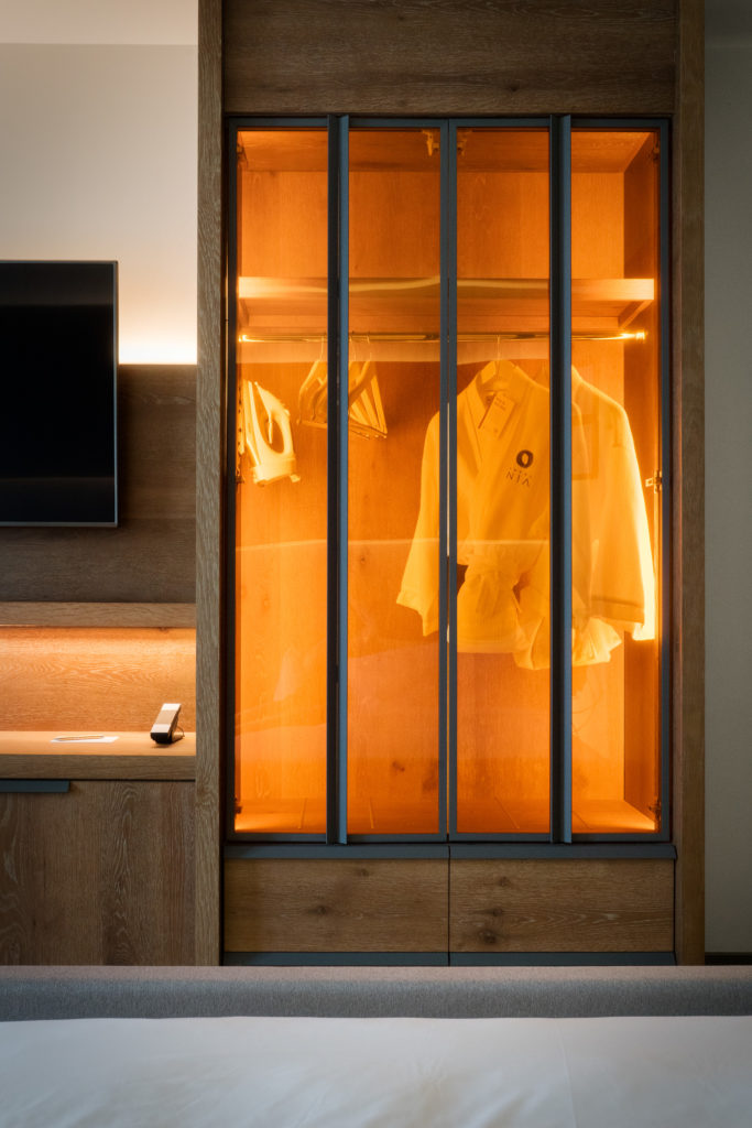guest room at Hotel Nia with see-through closet with light turned on