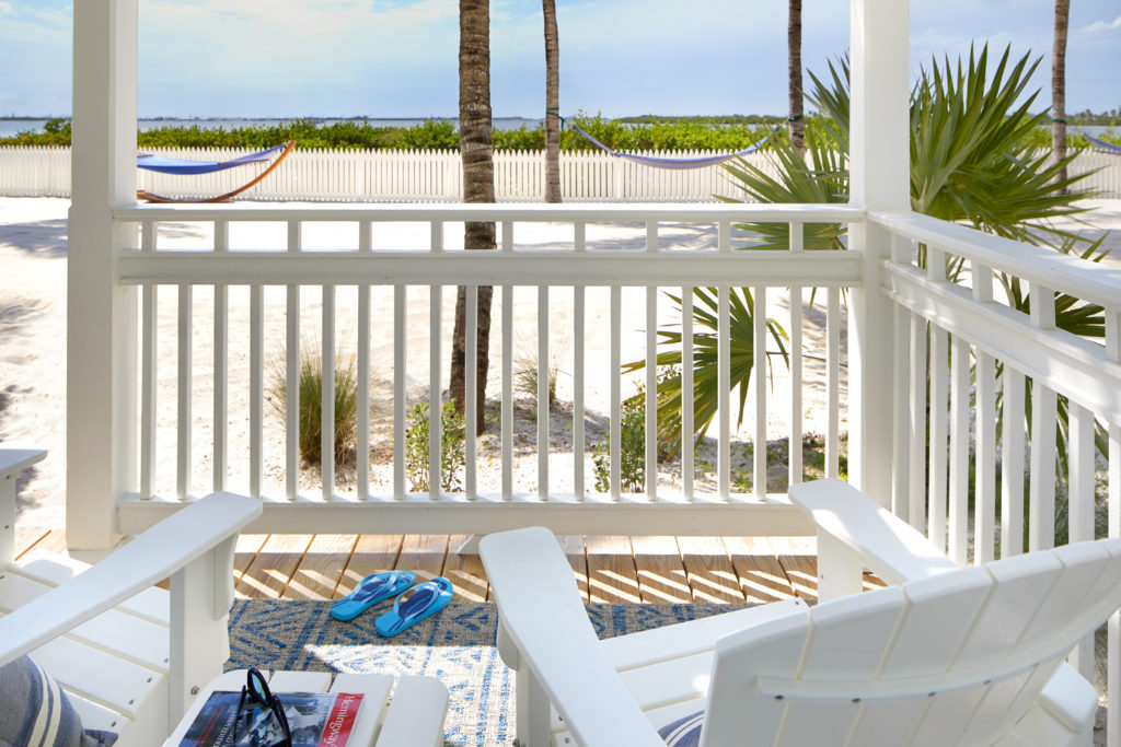 Adirondack chairs on patio overlooking beach in Waterfront Suite at Parrot Key Hotel & Villas