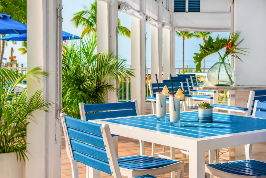 A row of tables and chairs at Tides Beachside Bar & Grill at Islander Resort