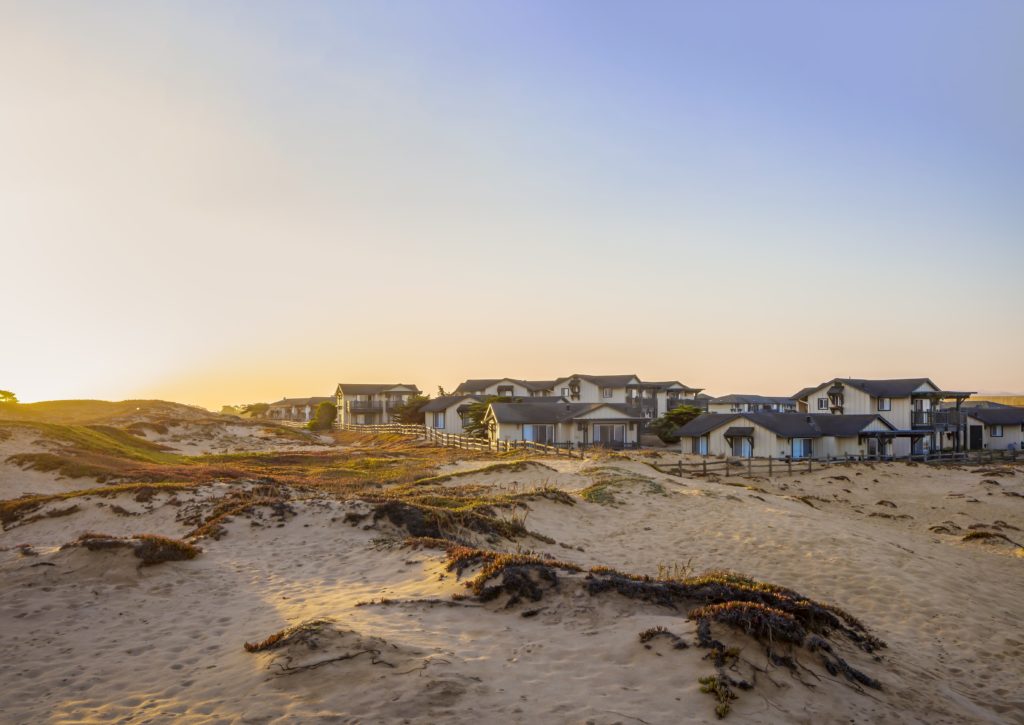 Exterior of The Sanctuary Beach Resort in Monterey, CA surrounded by sand dunes