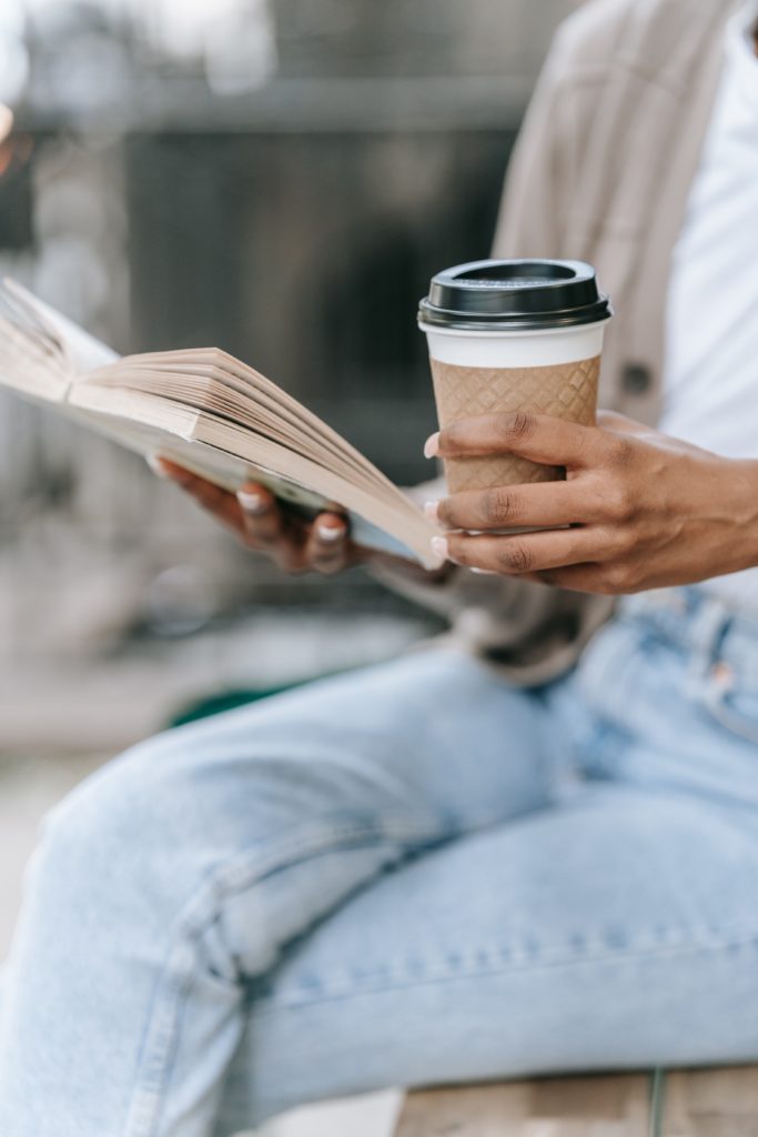 Woman Reading Book and Holding Coffee