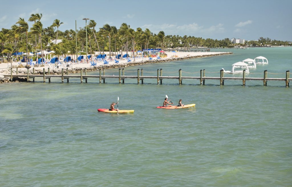 Kayakers paddling along fishing pier at Islander Resort