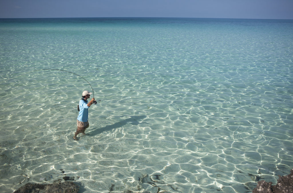 Man fly fishing in a clear sea